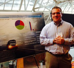 Photo of Alex Berryman by a board explaining his research
